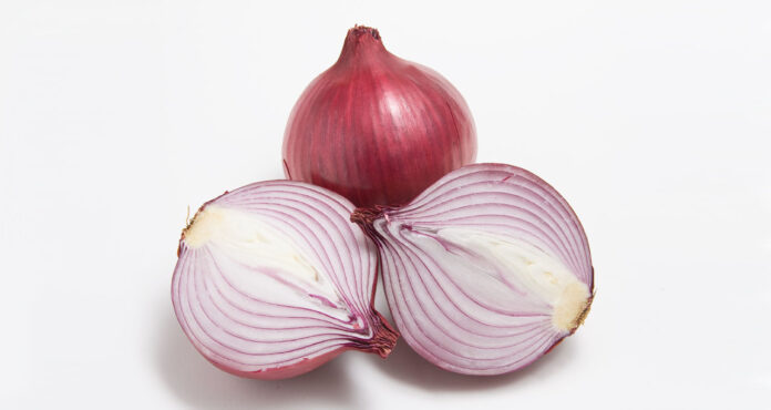 A red onion with an onion cut in half on a white background.